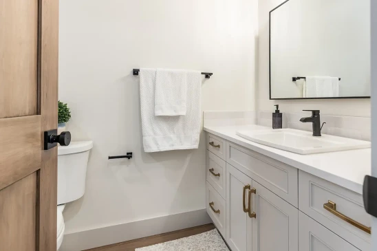 Contemporary powder room in RTM home with white vanity, brass hardware and matte black faucet in Alberta and Saskatchewan
