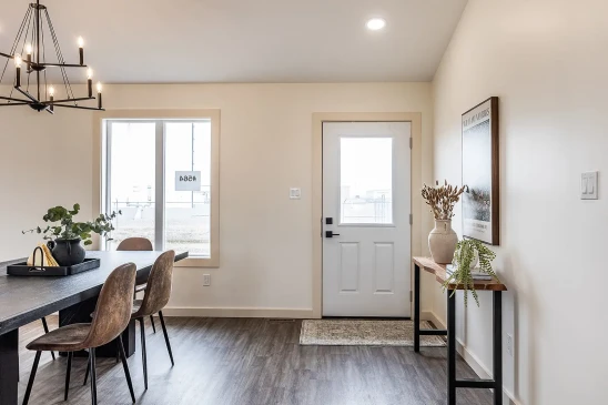 Modern RTM home dining space with black farmhouse table and upholstered chairs in Alberta and Saskatchewan