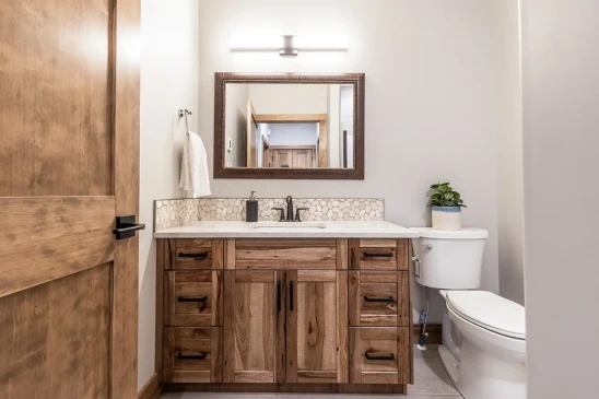 Custom wood bathroom vanity with stone countertop and framed mirror in RTM home in Alberta and Saskatchewan