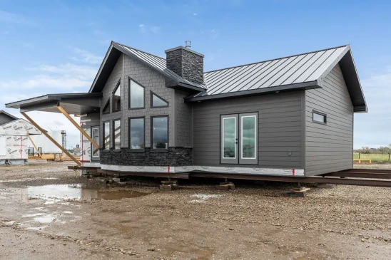 Finished modern RTM home exterior with metal roof and stone detailing, ready-to-move home available in Alberta and Saskatchewan