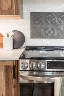 Stainless steel range with decorative tile backsplash in custom RTM home kitchen in Alberta and Saskatchewan